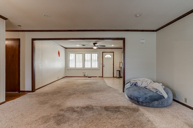 interior space with a textured ceiling, ceiling fan, and ornamental molding