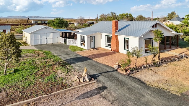 101 N 7th St, Marathon, TX 79842 - ranch-style house with an outdoor structure, a garage, a chimney, metal roof, and driveway