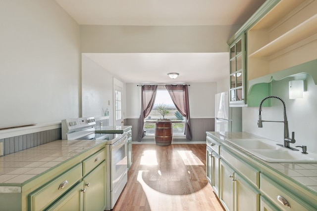 101 N 7th St, Marathon, TX 79842 - kitchen with white appliances, green cabinets, a sink, tile countertops, and light wood finished floors
