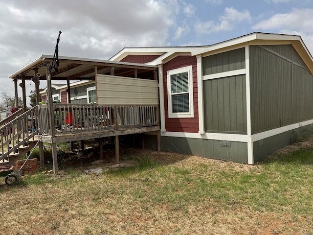 rear view of property featuring a yard and a deck