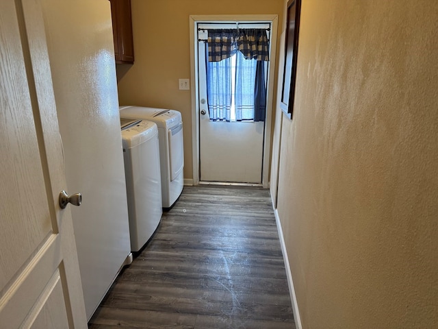 laundry area with dark wood finished floors, cabinet space, baseboards, and washer and dryer
