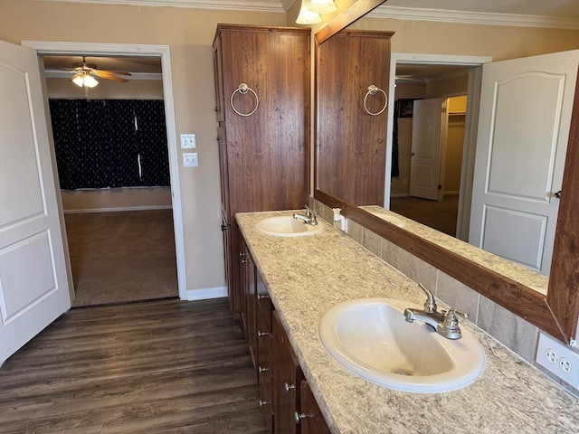 full bath featuring a sink, ornamental molding, a ceiling fan, and wood finished floors