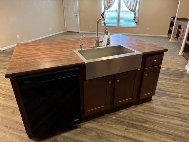 kitchen with dark brown cabinets, a sink, dishwasher, butcher block countertops, and baseboards