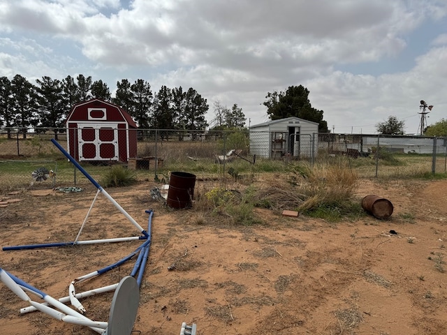 view of yard featuring an outdoor structure, fence, and a shed