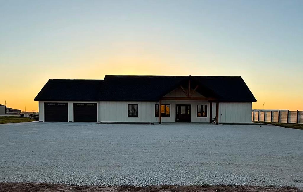 modern farmhouse featuring a detached garage, board and batten siding, and fence