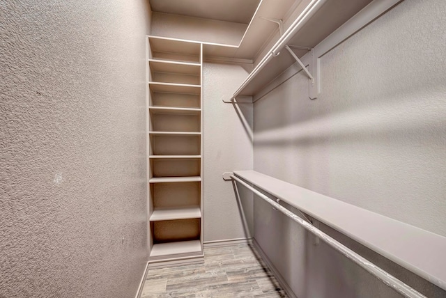 walk in closet with light wood-type flooring