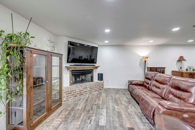 living room featuring hardwood / wood-style floors and a brick fireplace