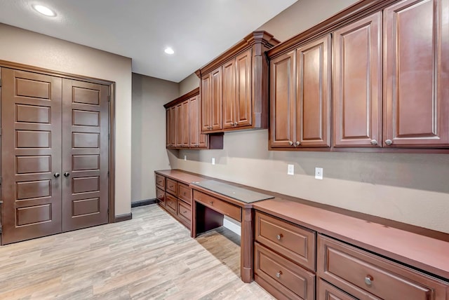 office area with light hardwood / wood-style flooring and built in desk