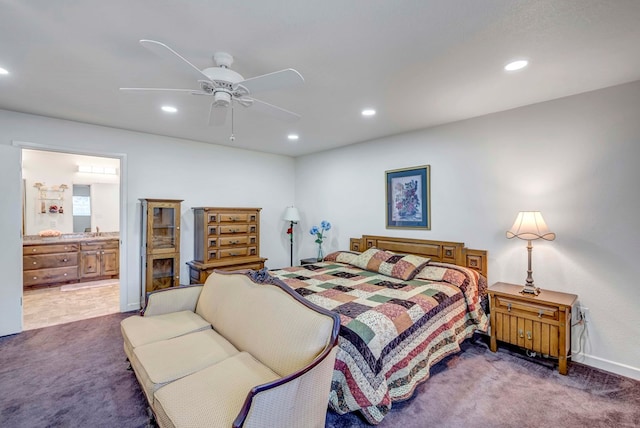 bedroom with connected bathroom, dark carpet, and ceiling fan