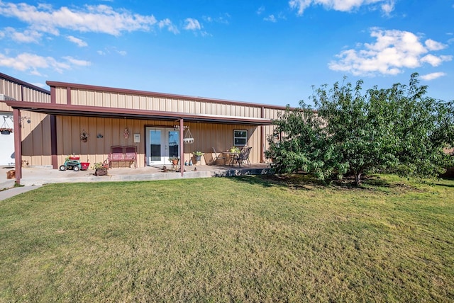 back of house featuring a lawn and a patio area