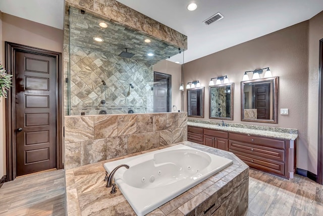 bathroom with independent shower and bath, vanity, and hardwood / wood-style floors