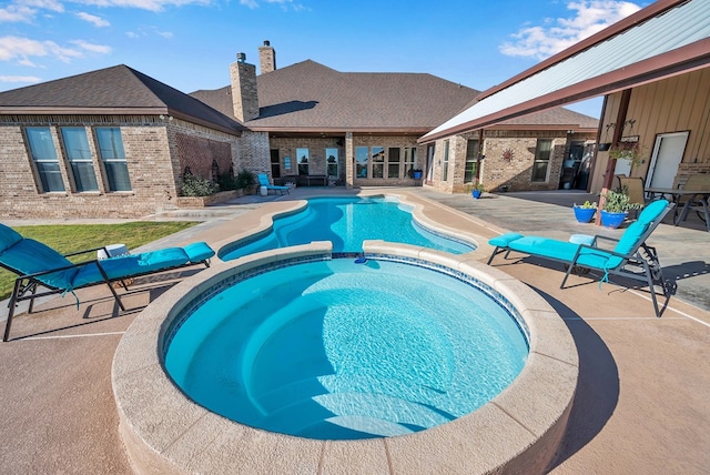 view of pool with an in ground hot tub and a patio area