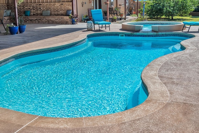 view of swimming pool featuring a patio and an in ground hot tub