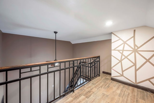 hallway featuring vaulted ceiling and light hardwood / wood-style floors