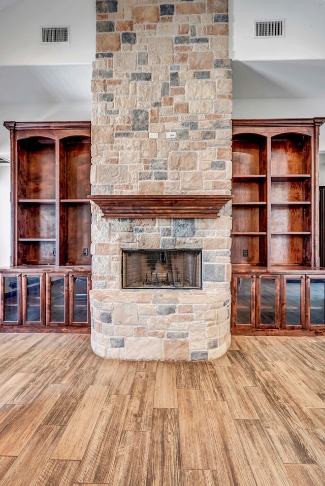 unfurnished living room with a fireplace, wood-type flooring, and high vaulted ceiling