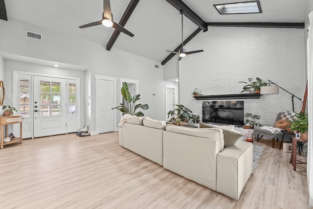6338 Mecca St, Odessa, TX 79762 - living area featuring a ceiling fan, light wood-type flooring, beam ceiling, brick wall, and high vaulted ceiling