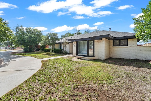 6338 Mecca St, Odessa, TX 79762 - view of front of home featuring a front yard, brick siding, and roof with shingles