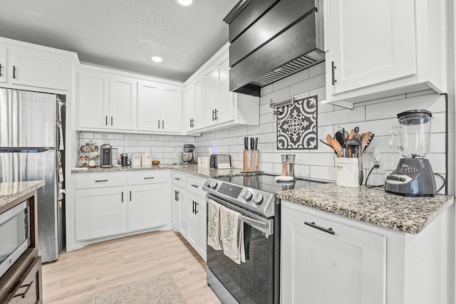 6338 Mecca St, Odessa, TX 79762 - kitchen with appliances with stainless steel finishes, custom range hood, backsplash, white cabinetry, and a textured ceiling