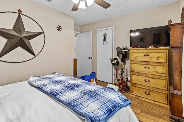 1703 Hemphill Ave, Odessa, TX 79763 - bedroom with wood finished floors, a textured ceiling, and ceiling fan