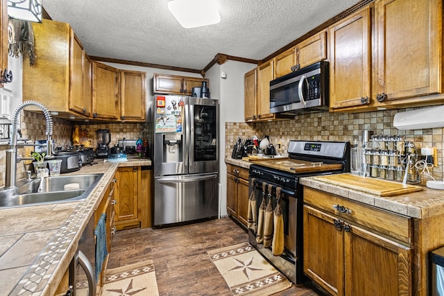 1703 Hemphill Ave, Odessa, TX 79763 - kitchen with stainless steel appliances, dark wood finished floors, brown cabinetry, backsplash, and a textured ceiling