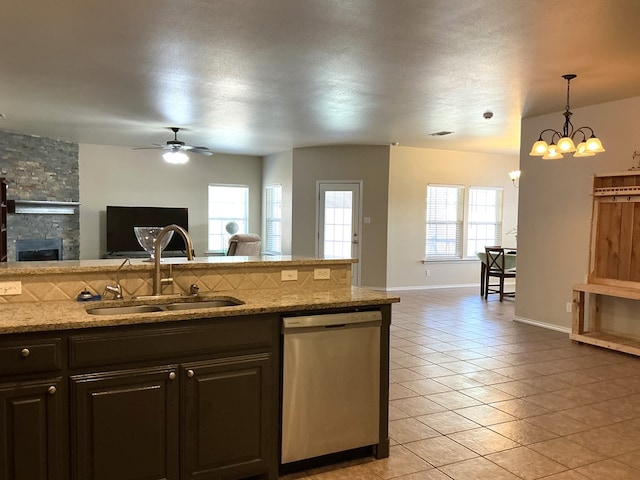 2804 Anice St, Odessa, TX 79762 - kitchen featuring dishwasher, a sink, open floor plan, light tile patterned flooring, and a stone fireplace