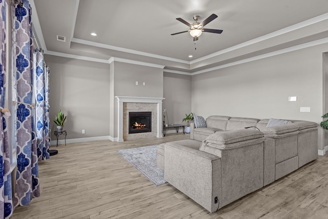 8620 Rutland Dr, Odessa, TX 79765 - living room featuring a raised ceiling, ceiling fan, a glass covered fireplace, wood finished floors, and ornamental molding