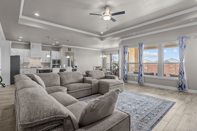 8620 Rutland Dr, Odessa, TX 79765 - living room featuring a tray ceiling, ceiling fan, light wood-style floors, a chandelier, and recessed lighting