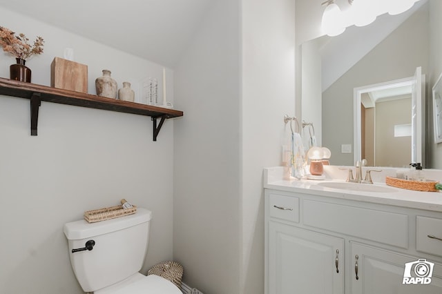 half bath with vanity, lofted ceiling, and toilet