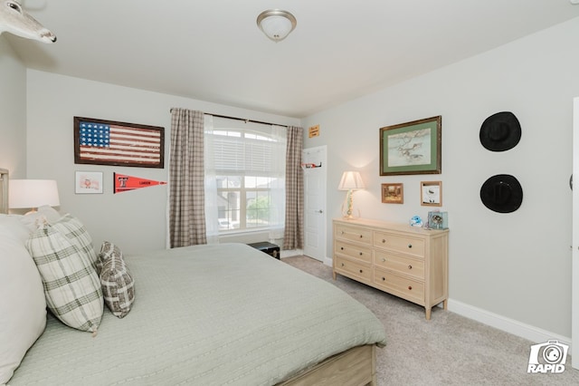 bedroom featuring baseboards and light carpet