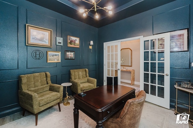 office area with french doors, a decorative wall, and a notable chandelier