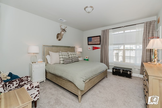 carpeted bedroom featuring baseboards and visible vents