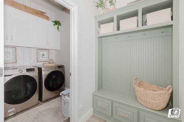 laundry room with baseboards, cabinet space, and washing machine and clothes dryer