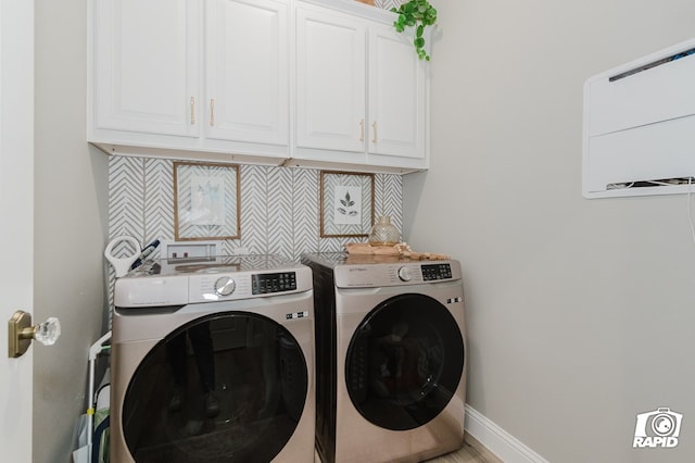 laundry room featuring washer and dryer, baseboards, and cabinet space
