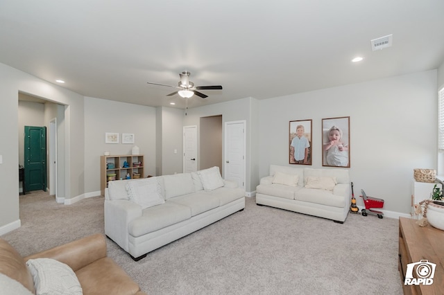 living room with light colored carpet, a ceiling fan, visible vents, and baseboards