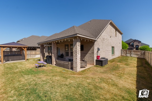 back of house with a fenced backyard, a gazebo, a hot tub, and a patio area