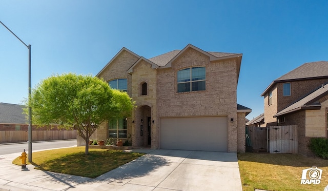 traditional home with concrete driveway, brick siding, fence, and a garage