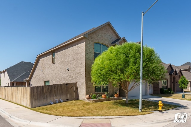 view of side of property featuring fence, brick siding, a garage, a yard, and driveway