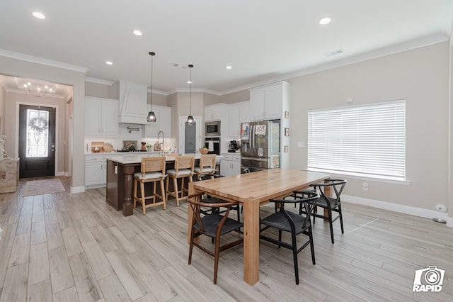 dining space with baseboards, light wood finished floors, a notable chandelier, ornamental molding, and recessed lighting