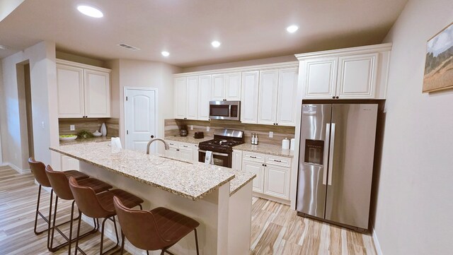 3630 El Cajon Ave, Odessa, TX 79765 - kitchen featuring stainless steel appliances, white cabinets, light wood-style flooring, decorative backsplash, and recessed lighting