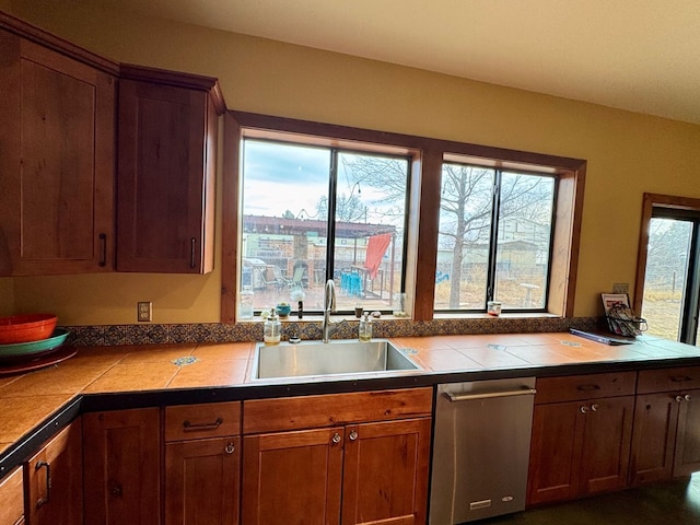 kitchen with sink, a wealth of natural light, tile countertops, and dishwasher