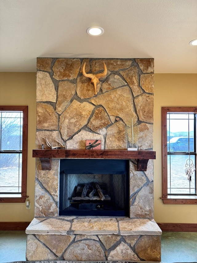 interior details featuring carpet flooring and a stone fireplace