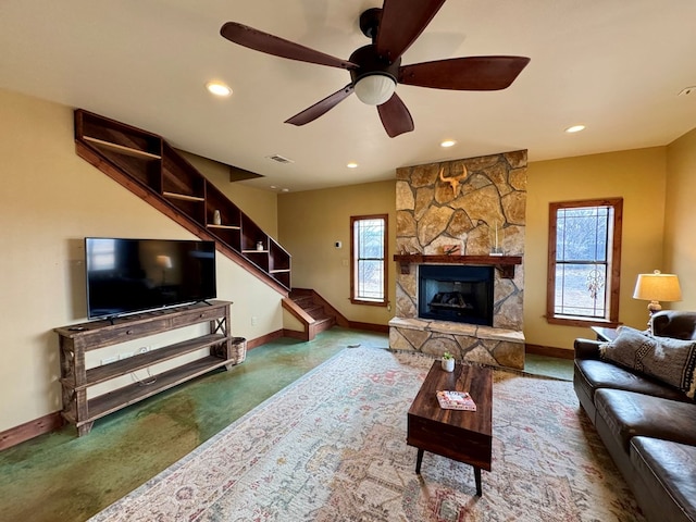 living room with a stone fireplace and ceiling fan