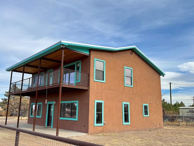 view of home's exterior with a balcony and a patio