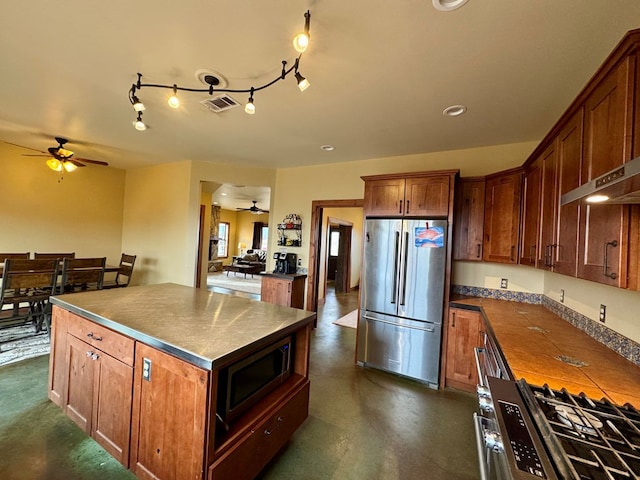 kitchen featuring stainless steel appliances, ceiling fan, and a kitchen island