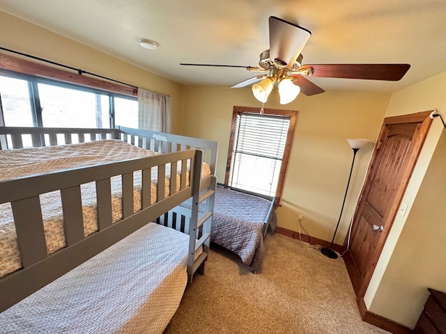 bedroom with multiple windows, ceiling fan, and carpet