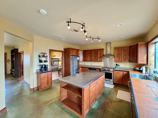 kitchen featuring high end appliances, a kitchen island, sink, and wall chimney exhaust hood