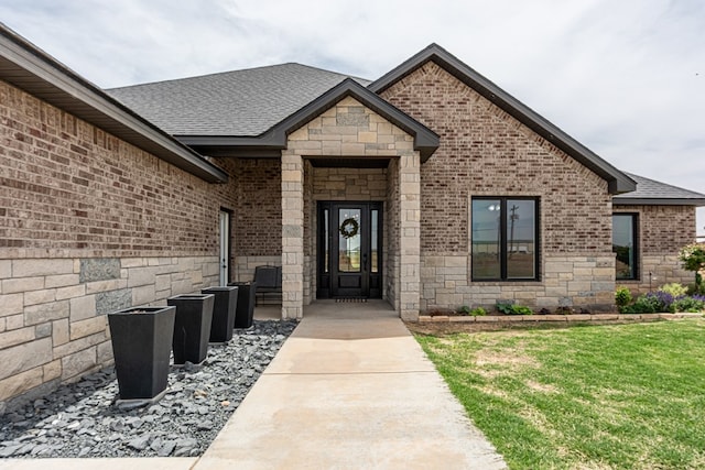 479 County Rd 306, Seminole, TX 79360 - view of exterior entry featuring a lawn, a shingled roof, stone siding, and brick siding