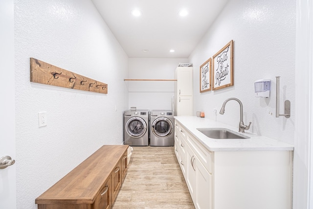 479 County Rd 306, Seminole, TX 79360 - clothes washing area featuring washing machine and dryer, a sink, a textured wall, recessed lighting, and light wood-style flooring
