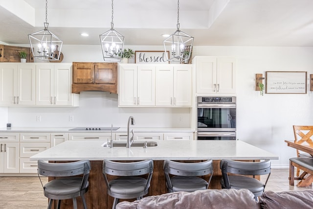 479 County Rd 306, Seminole, TX 79360 - kitchen featuring a sink, double oven, a breakfast bar area, a chandelier, and white cabinetry