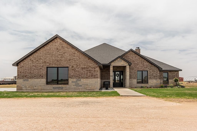 479 County Rd 306, Seminole, TX 79360 - view of front of property featuring brick siding, roof with shingles, stone siding, and a chimney